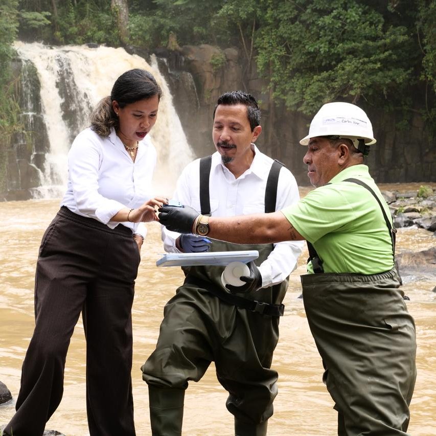 Equipo técnico de campo coordinando trabajo de evaluación ambiental en un entorno fluvial.